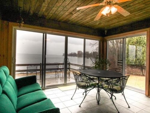 a living room with a ceiling fan and a table and chairs at Home Away from Home in North Hero