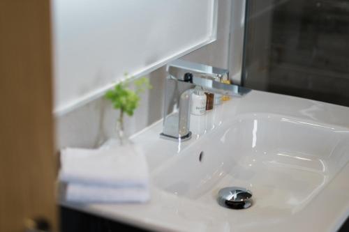 a bathroom sink with a faucet on a counter at 1863 Restaurant with Rooms in Pooley Bridge