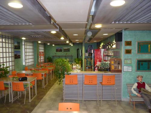 フジェンスコにあるHotel Devítkaのオレンジ色の椅子とテーブルが備わるレストラン