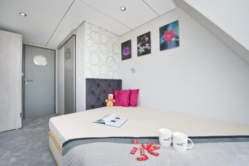 Houseboat في Błotnik: غرفة نوم بسرير عليها نعال حمراء