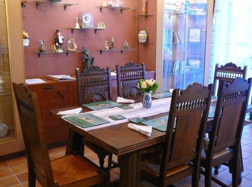 une salle à manger avec une table avec des chaises et un buffet dans l'établissement La Mare aux Fées, à Huelgoat
