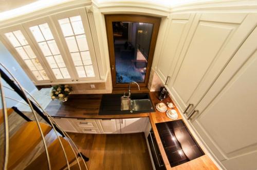 a small kitchen with a sink and a mirror at Apartamenty Euphoria in Gołdap