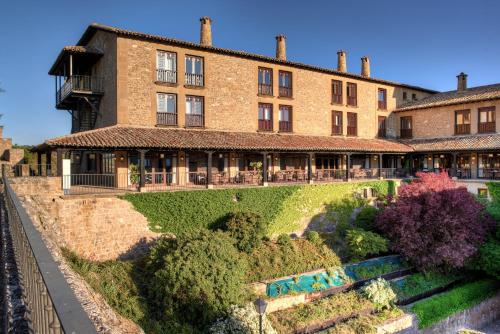 un gran edificio de ladrillo con un jardín delante de él en Parador de Sos del Rey Católico, en Sos del Rey Católico