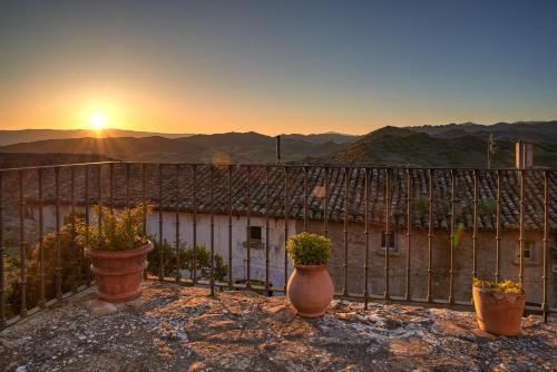 three pots on a fence with the sunset in the background at Parador de Sos del Rey Católico in Sos del Rey Católico
