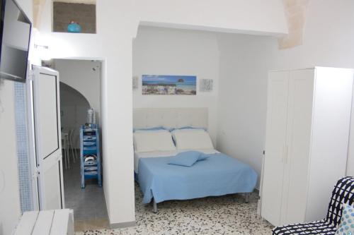 ein weißes Schlafzimmer mit einem Bett und einem Stuhl in der Unterkunft you & me house in Ceglie Messapica