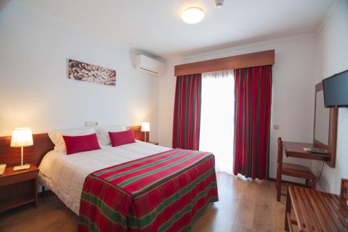 a hotel room with a bed and a window at Hotel Cristo Rei - Fatima in Fátima