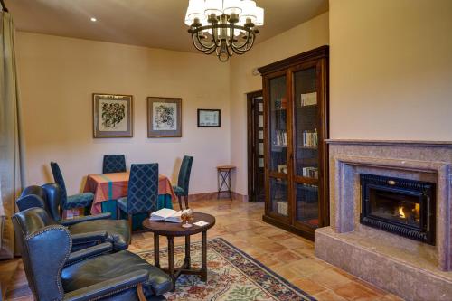 a living room with a fireplace and a table and chairs at Parador de Sos del Rey Católico in Sos del Rey Católico