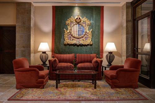 a living room with two chairs and a mirror at Parador de Sos del Rey Católico in Sos del Rey Católico