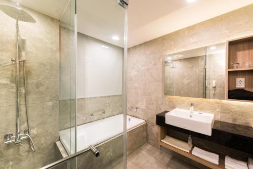 a bathroom with a shower and a sink and a tub at Shin Yuan Park Hotel in Hsinchu City