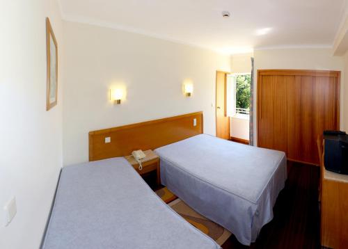 a hotel room with two beds and a television at Hotel Caldelas in Caldelas