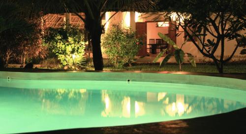 a swimming pool in front of a house at Baobab Village in Watamu