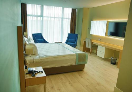 a hospital room with a bed and two blue chairs at The Ankara Hotel in Ankara