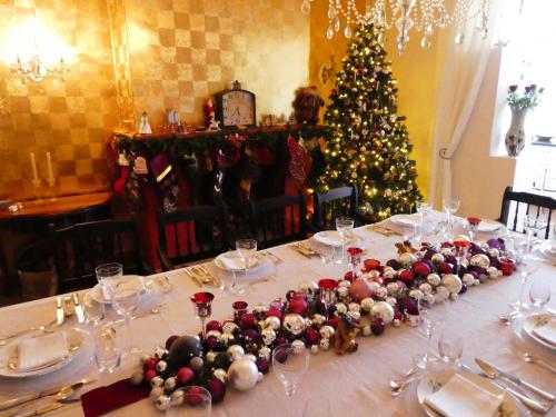 a table with a christmas tree in the background at Sorgvry - House of Guests in Barrydale