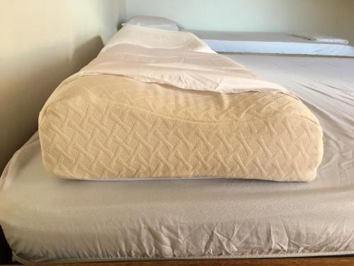 an unmade bed with a tan blanket on it at Hotel Pizzeria Opera Tolú in Tolú