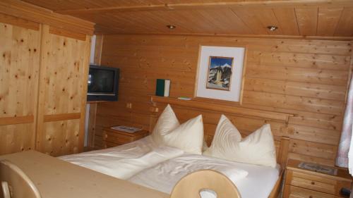 a bedroom with a bed in a wooden room at Gasthaus Oberweissen-Hittl in Sankt Jakob in Defereggen