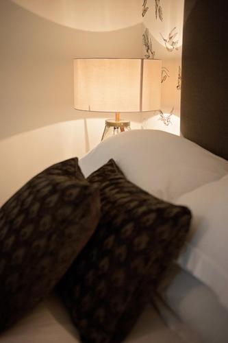 a close up of a bed with a pillow and a lamp at The George Great Oxendon in East Farndon