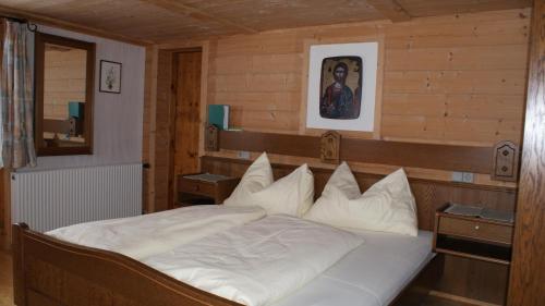 a bedroom with a large bed with white pillows at Gasthaus Oberweissen-Hittl in Sankt Jakob in Defereggen