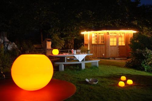a picnic table with a lit up gazebo at night at Hotel & Spezialitätenrestaurant zur Linde in Teufen