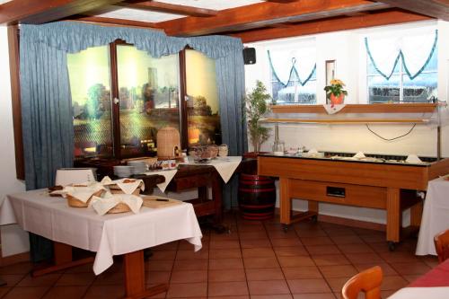 Hotel Küferschänke في سينشيم: غرفة طعام بطاولتين و بيانو
