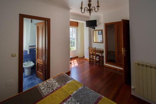 a bedroom with a bed and a bathroom with a sink at As Areas I in Viveiro