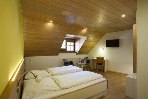 a bed in a room with a wooden ceiling at Gästehaus am Westtor in Prichsenstadt