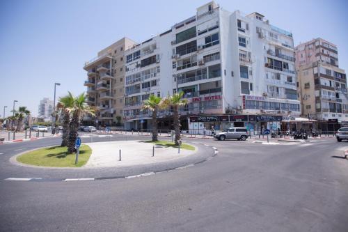an empty street in a city with a large building at Spat Beach in Bat Yam