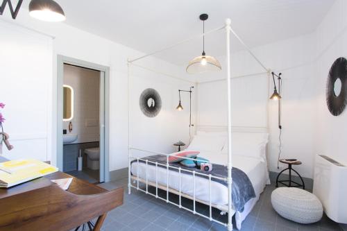 a bedroom with a canopy bed with a desk at Intervallo Boutique Hotel in Ragusa