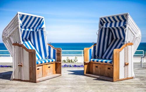two chairs sitting on a deck near the beach at Hotel Bryza Resort & Spa in Jurata