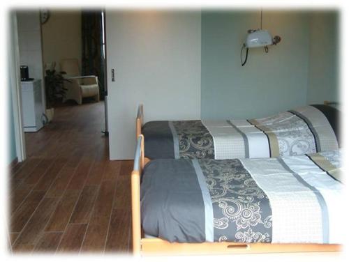 two beds in a room with a hallway and a room with at Fruitbedrijf Stek in Kedichem