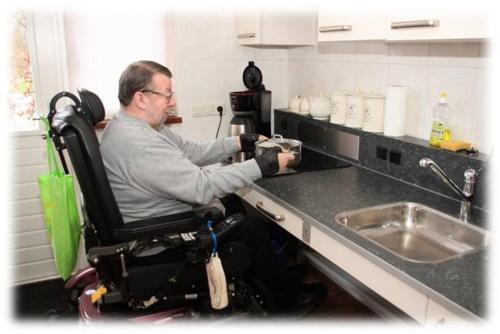 a man in a wheel chair in a kitchen at Fruitbedrijf Stek in Kedichem