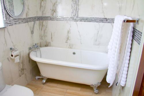 a white bath tub in a bathroom with a toilet at Estoby Executive guest house in Witbank