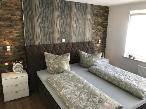 a bed with two pillows on it next to a window at Ermmes Ferienwohnungen in Sinsheim