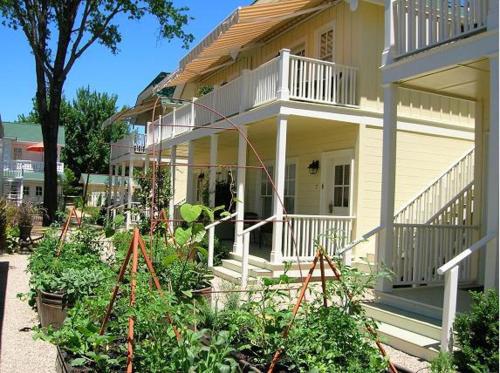 a white house with a porch and some plants at Tallman Hotel in Upper Lake