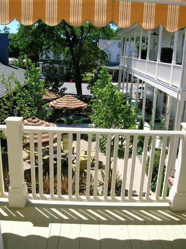 a white fence on a porch with an umbrella at Tallman Hotel in Upper Lake