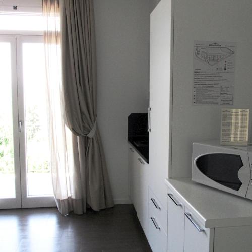 a white kitchen with a microwave and a window at Residence Fiesole in Fiesole
