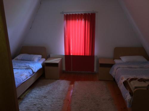 a room with two beds and a red curtain at Holiday Home Mrljes in Rast