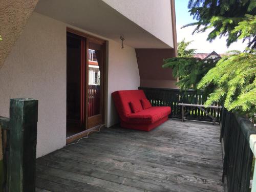 a red chair sitting on the porch of a house at Holiday Home Mrljes in Rast
