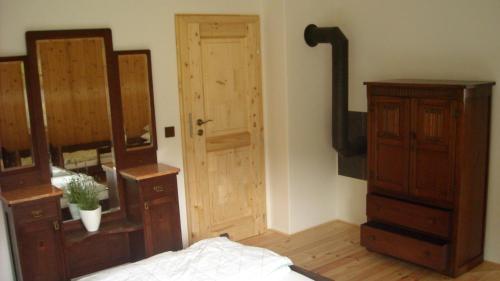 a bedroom with a bed and a dresser and a door at Chalupa za Křížkem in Malá Morávka