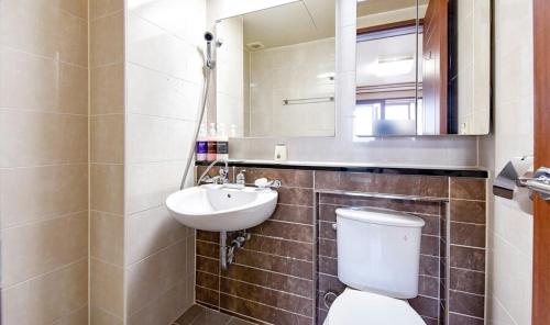 uma casa de banho com um WC, um lavatório e um espelho. em Hillstay Residence Hotel em Gumi