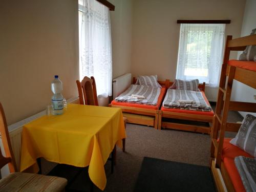 a room with two beds and a table with a yellow table cloth at Zrcadlová Koza in Turnov
