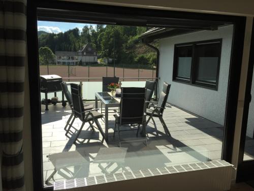 Elle offre une vue sur une terrasse avec une table et des chaises. dans l'établissement Ferienhaus am Rarbach, à Schmallenberg