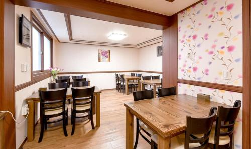 uma sala de jantar com mesas e cadeiras de madeira em Hillstay Residence Hotel em Gumi