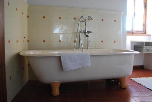 a bath tub with a towel on it in a bathroom at Casa Santa Giulia in Monteriggioni