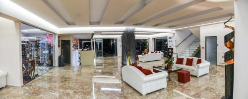 a living room with white couches and a lobby at Vallian Village Hotel in Paradeísion
