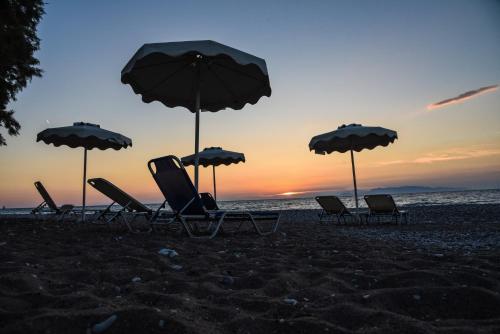 a group of chairs and umbrellas on a beach at Vallian Village Hotel in Paradeísion
