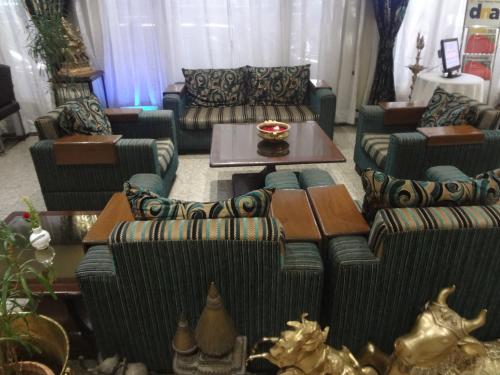 a living room with couches and a table at Hotel Midtown Pritam in Mumbai