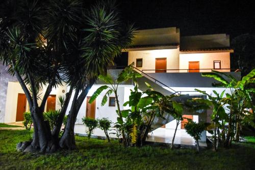 a white house with palm trees in front of it at Vallian Village Hotel in Paradeísion