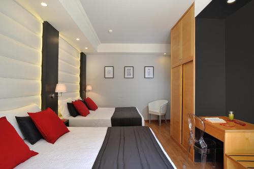 a bedroom with a bed with red pillows and a desk at Hotel Concord - Nel cuore di Riccione in Riccione