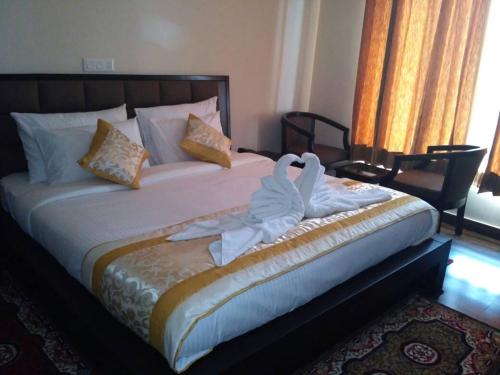 a bedroom with a bed with a swan decoration on it at Chimbalhar Heights in Pālampur