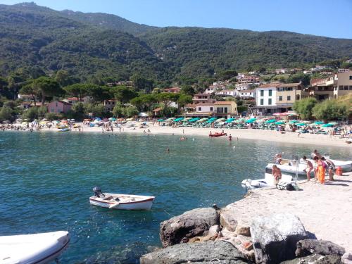 a beach with people and boats in the water at B & B Summer in Marciana